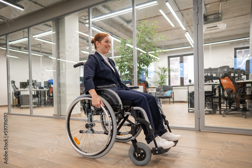 Caucasian woman wheelchair in open space office. © Михаил Решетников