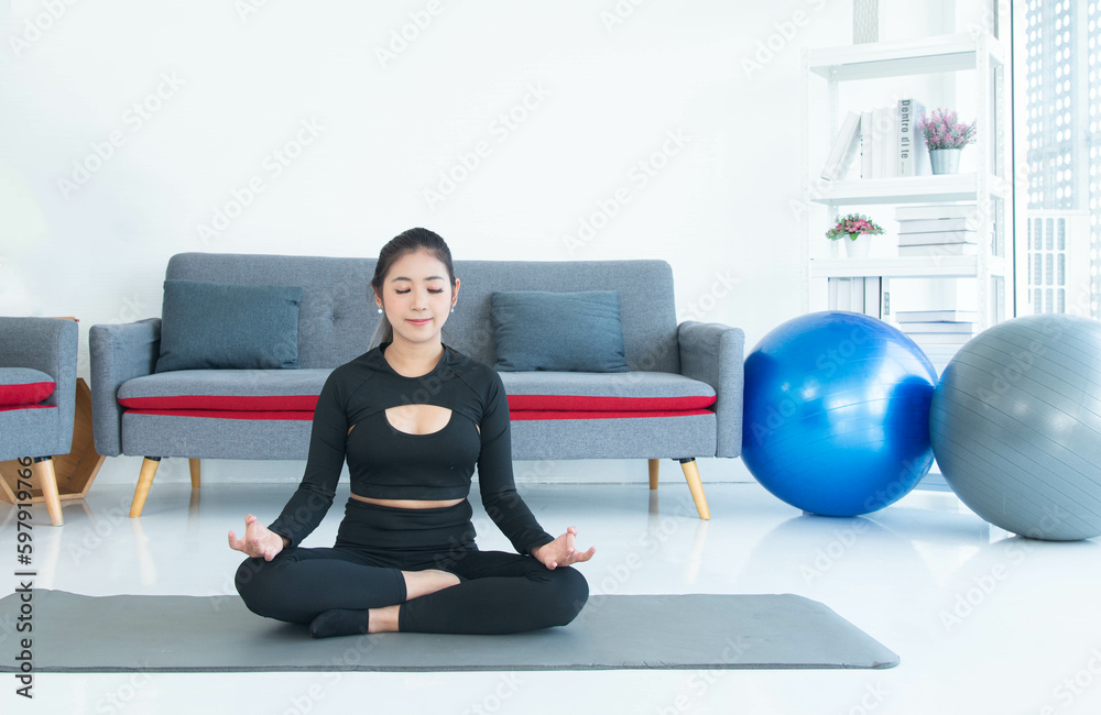 Asian young healthy woman in sportware practicing yoga at home, Sport girl meditating in living room at home Asian young healthy woman in sportware practicing yoga at home, Sport girl meditating in living room at home