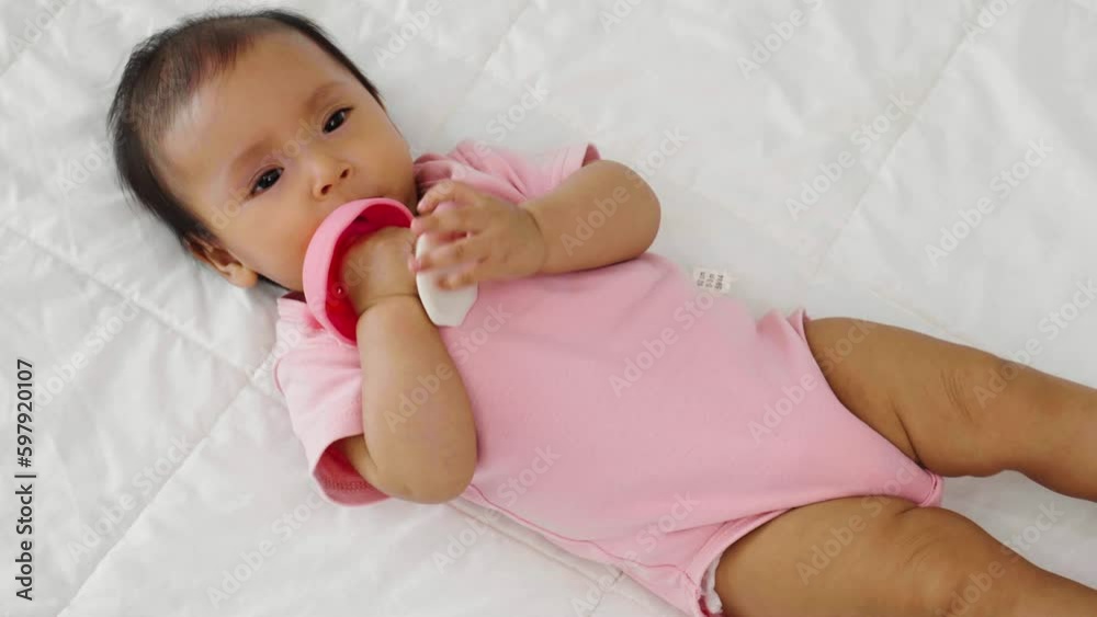 infant baby biting mushroom teether rubber toy on a bed infant baby biting mushroom teether rubber toy on a bed