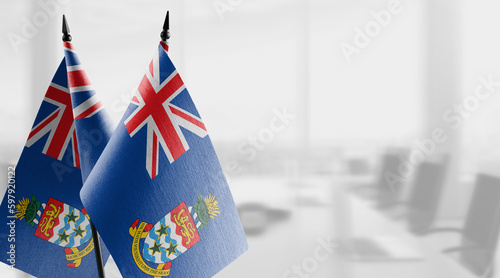 Fototapeta Naklejka Na Ścianę i Meble -  Small flags of the Cayman Islands on an abstract blurry background