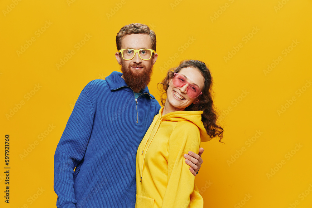 Man and woman couple smiling cheerfully and crooked with glasses, on yellow background, symbols signs and hand gestures, family shoot, newlyweds. Man and woman couple smiling cheerfully and crooked with glasses, on yellow background, symbols signs and hand gestures, family shoot, newlyweds.