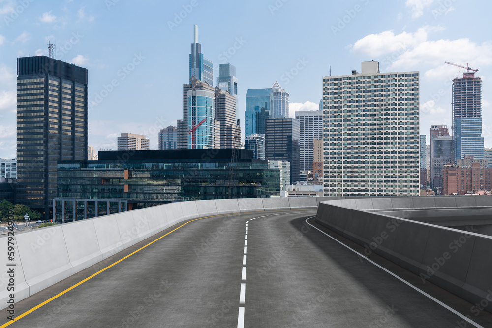 Obraz premium Empty urban asphalt road exterior with city buildings background. New modern highway concrete construction. Concept way to success. Transportation logistic industry fast delivery. Philadelphia. USA.
