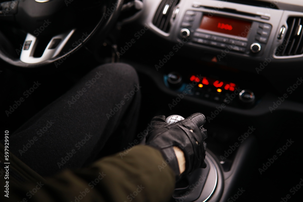 Hand on the car gear knob. The driver switches the speed in the car