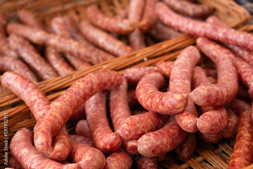 Traditionally prepared dried sausages (in dutch 'Metworst' or 'droge worst'), made of raw minced pork, lie in a wicker basket at a butcher's shop