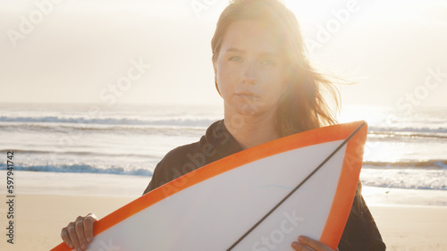 Woman surfer stands with surfing board on the tropical beach. Portrait of arrogant female surfer photo