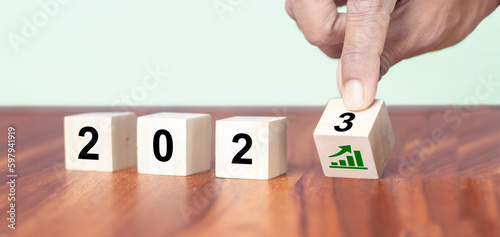 Business growth concept in 2023. Business goals and achievement. Sustainable development. Wooden cubes inscripted 2023 and growth icon on smart background. Positive indicators banner photo