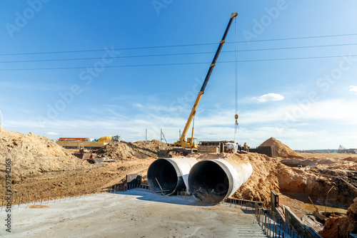 Connecting a trench drain to a concrete manhole structure at construction site. Concrete pile in formwork frame for construct stormwater and underground utilities, pump stations, sewers pipes