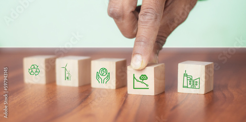 Low carbon,carbon neutral concept. Net zero greenhouse gas emissions target. Climate neutral long term strategy. Hand put wooden cubes with decrease carbon emission icon and green icon. Green banner