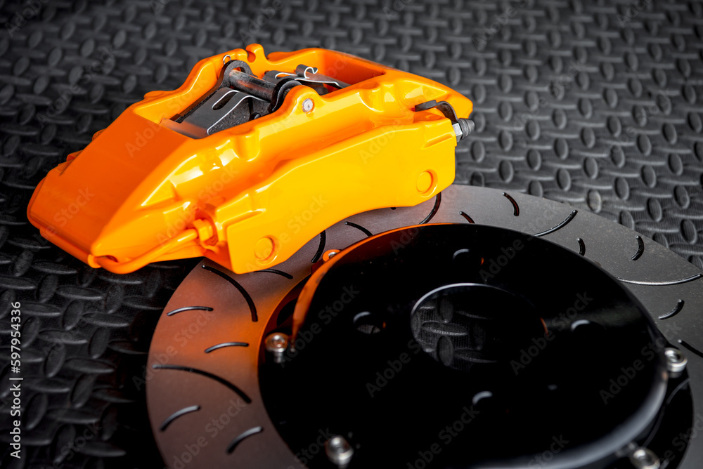 Car mechanic or serviceman disassembly and checking a disc brake and asbestos brake pads for fix and repair problem at car garage or repair shop Car mechanic or serviceman disassembly and checking a disc brake and asbestos brake pads for fix and repair problem at car garage or repair shop