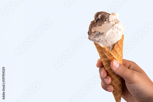 Hand holding delicious cookies and cream ice cream in a crispy waffle cone with copy space. Created with Generative AI Technology