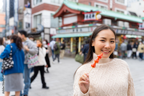 Photography Happy Asian woman eating Japanese sweet candy during travel at Sensoji Temple in Asakusa, Tokyo, Japan