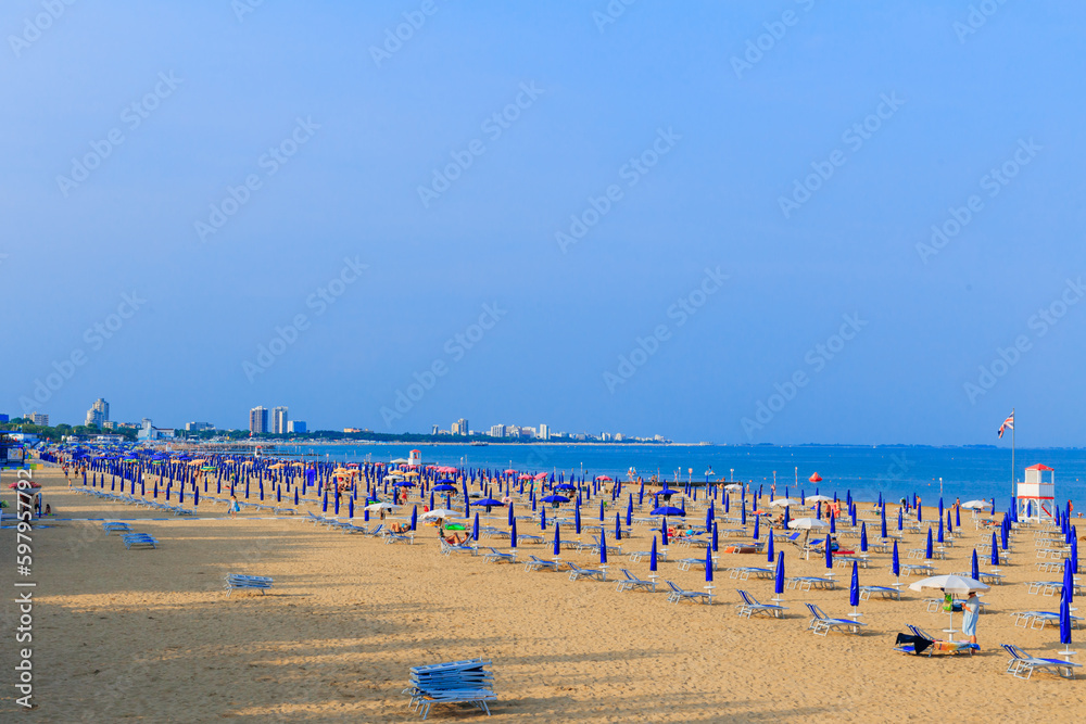sandy beach with umbrellas and blue sea. distant buildings of the city sandy beach with umbrellas and blue sea. distant buildings of the city