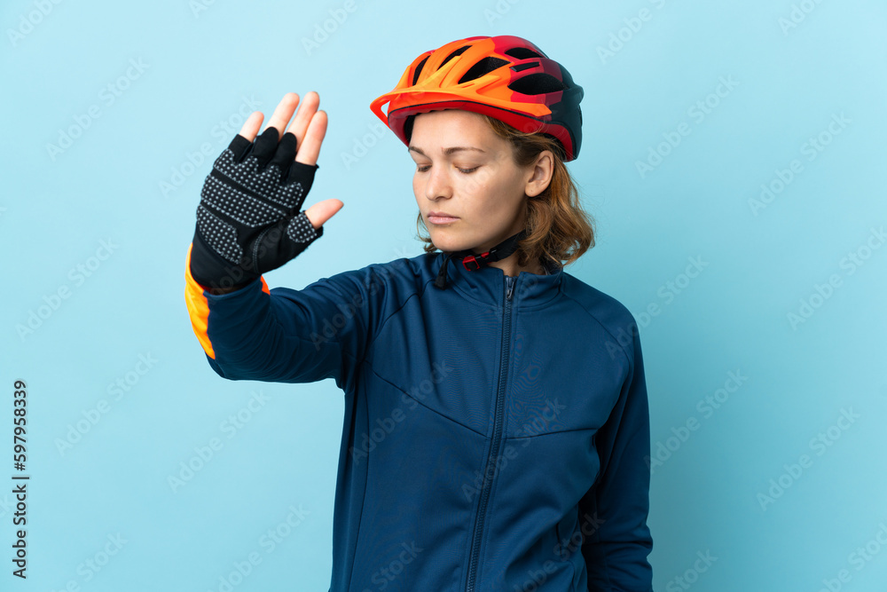 Young cyclist woman isolated on blue background making stop gesture and disappointed Young cyclist woman isolated on blue background making stop gesture and disappointed