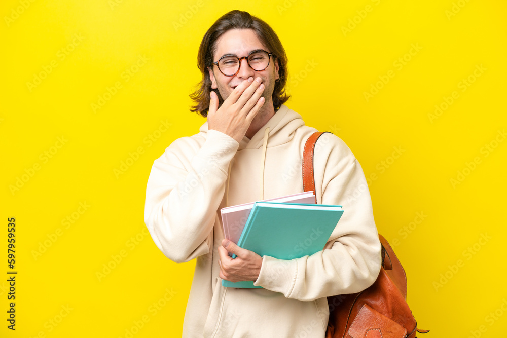 Young student handsome man isolated on yellow background happy and smiling covering mouth with hand Young student handsome man isolated on yellow background happy and smiling covering mouth with hand
