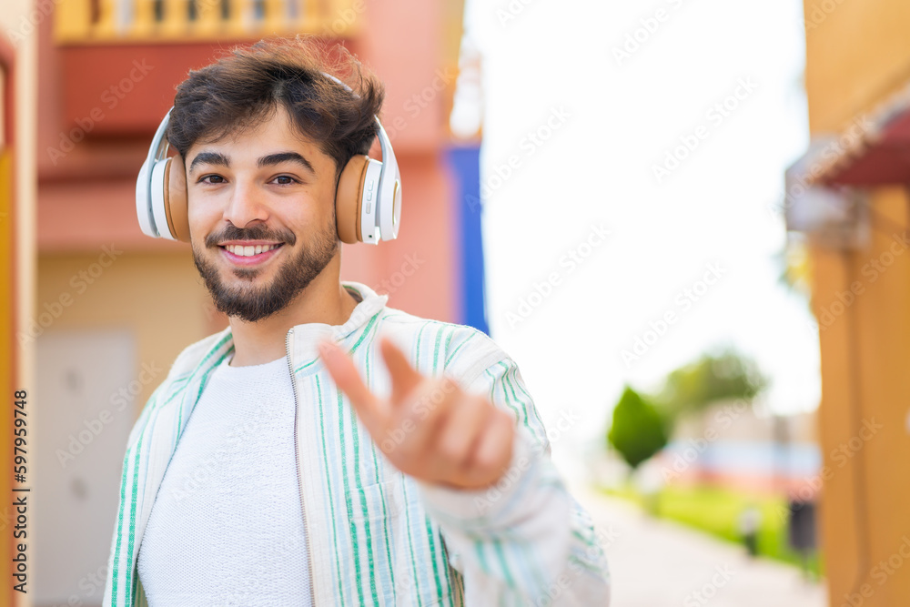 Obraz premium Handsome Arab man at outdoors listening music