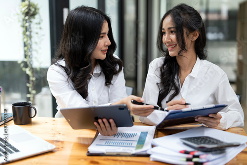 Shot of two asian businesswoman working together on digital tablet. Creative female executives meeting and discussing sitting at office.