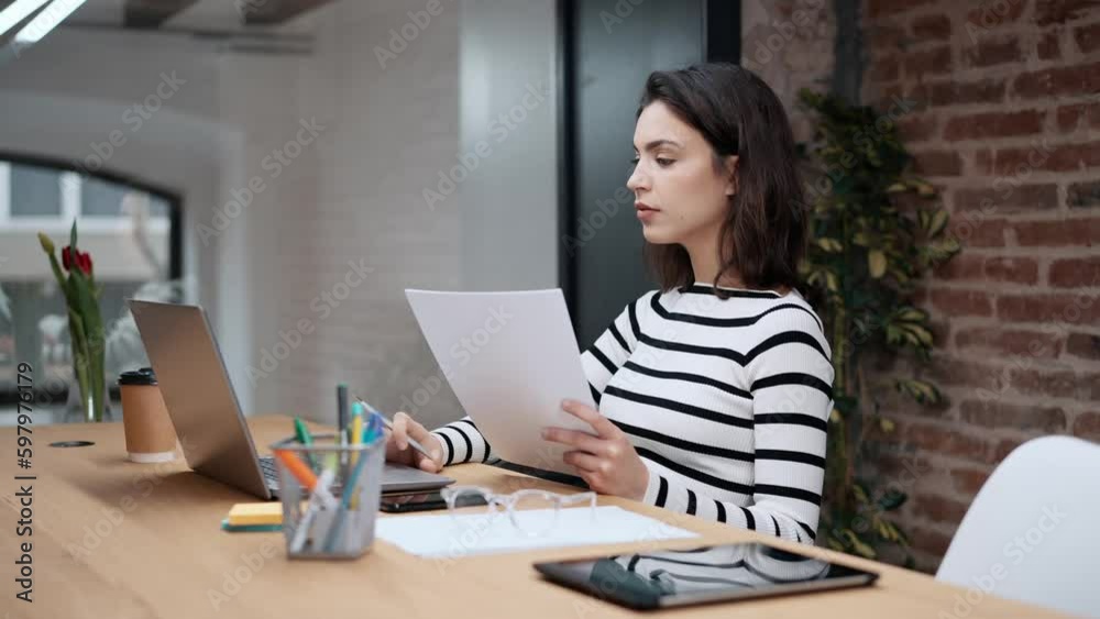 Video of architect engineer woman working with laptop while studying the blueprints in a modern office. Video of architect engineer woman working with laptop while studying the blueprints in a modern office.