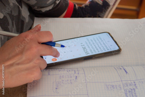 Calculating person with a mobile phone and a pen