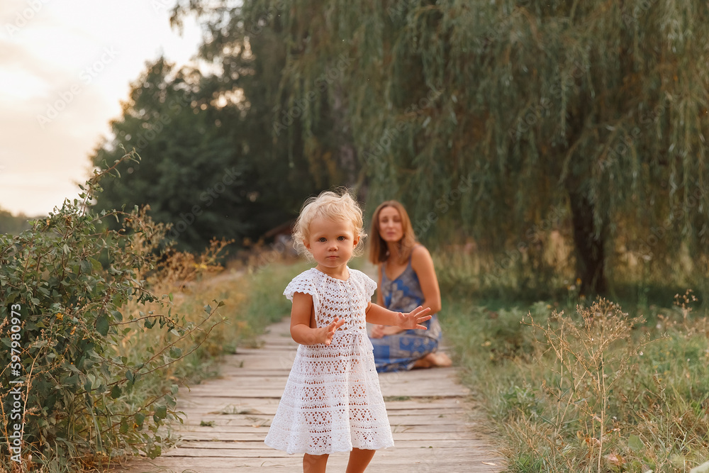 mother and daughter walk on the bridge by the water, girl in a hat on a wooden bridge, walk by the pond, pond, family near the lake
mother and daughter walk on the bridge by the water, girl in a hat on a wooden bridge, walk by the pond, pond, family near the lake