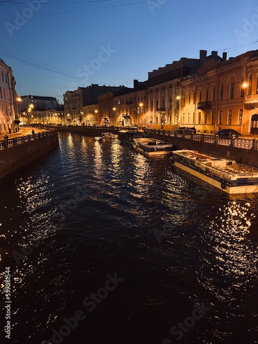 evening city river with ferries, bright sky after the sunset, white nights in Saint-petersburg