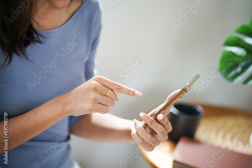 Asian Business woman using smart phone spending time checking news social media cell telephone technology e-commerce .