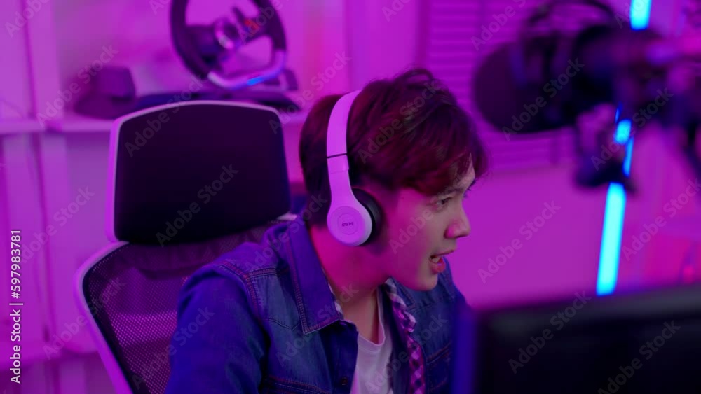 Portrait of young asian gamer man play computer pc. He lost, held his face in his hands, regretting the chance of win in tournament. Streaming game online at home. Lose and game over concept. Portrait of young asian gamer man play computer pc. He lost, held his face in his hands, regretting the chance of win in tournament. Streaming game online at home. Lose and game over concept.