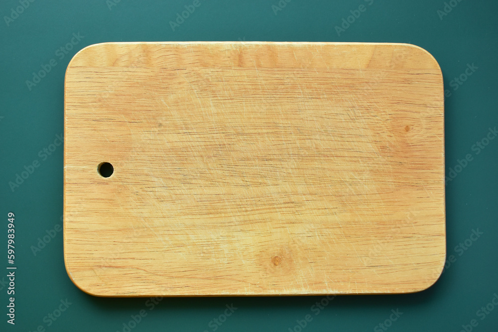 brown wooden cutting board on green background, equipment for cooking in the kitchen brown wooden cutting board on green background, equipment for cooking in the kitchen