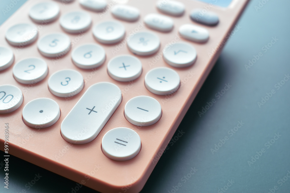 close up modern peach colour pastel calculator and white button on blue background, business and finance accounting concept close up modern peach colour pastel calculator and white button on blue background, business and finance accounting concept