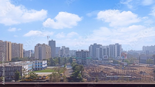 View from an building showing the construction work going on  a nearby school with buses  developments of the city.