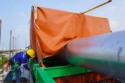 Fire blanket installation on pipeline to protection equipment and welder welding repairing at construction site project. 