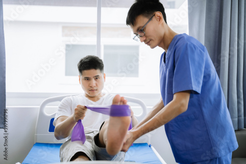 Patient at the physiotherapy doing physical exercises with therapist.