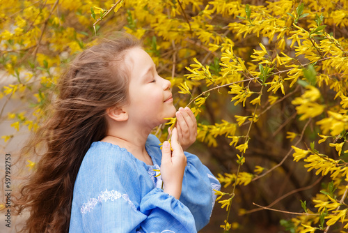 girl in an embroidered shirt in flowering trees  spring  flowering trees in spring  girl in bloom  vyshyvanka  