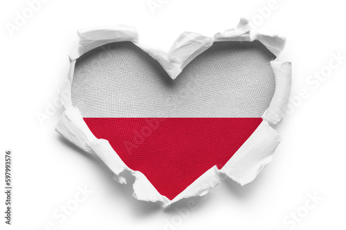 Heart shaped hole torn through paper, showing satin texture of flag of Poland, cut out