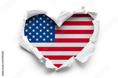 Heart shaped hole torn through paper, showing satin texture of flag of USA, cut out photo