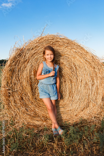 Children on round bales, mowed wheat, bales of wheat, children in Ukraine, wheat field, children in a wheat field with a beautiful sky, bales