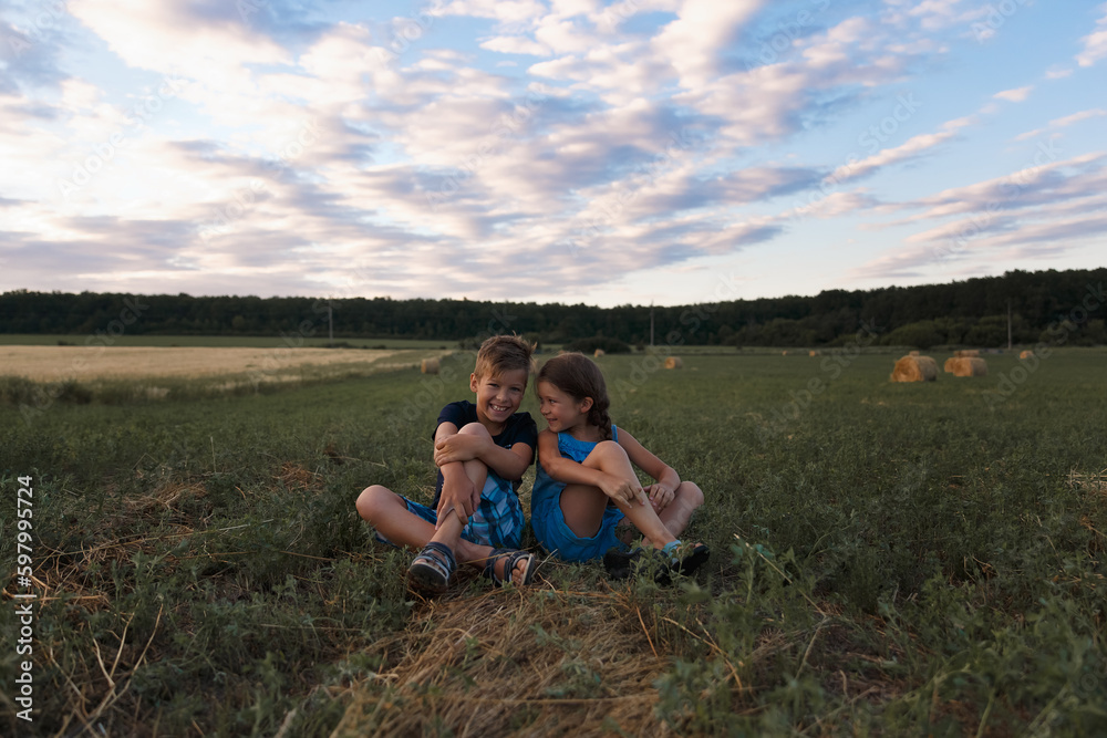 Children on round bales, mowed wheat, bales of wheat, children in Ukraine, wheat field, children in a wheat field with a beautiful sky, bales Children on round bales, mowed wheat, bales of wheat, children in Ukraine, wheat field, children in a wheat field with a beautiful sky, bales