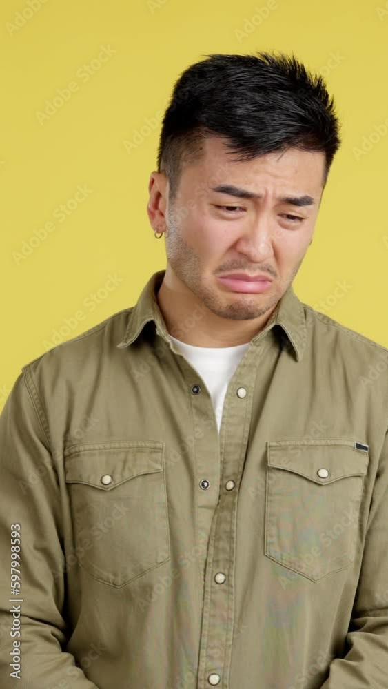 Sad handsome chinese man looking at camera