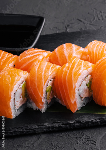 Sushi roll philadelphia with salmon on black board