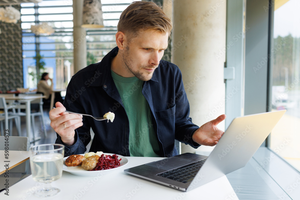 Young male entrepreneur working from a cozy lounge, taking a break to enjoy a healthy eating lunch and watch a video. Reflects a modern workplace that emphasizes mindfulness and healthy living Young male entrepreneur working from a cozy lounge, taking a break to enjoy a healthy eating lunch and watch a video. Reflects a modern workplace that emphasizes mindfulness and healthy living