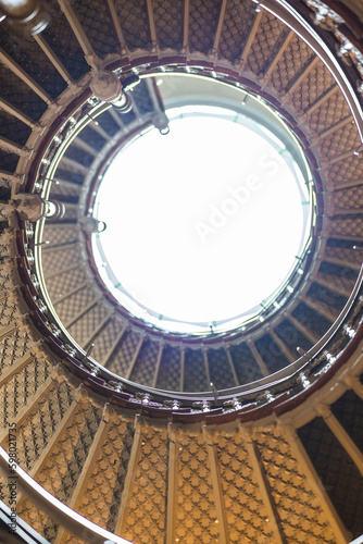 Spiral staircase with big skylight on top seen from below