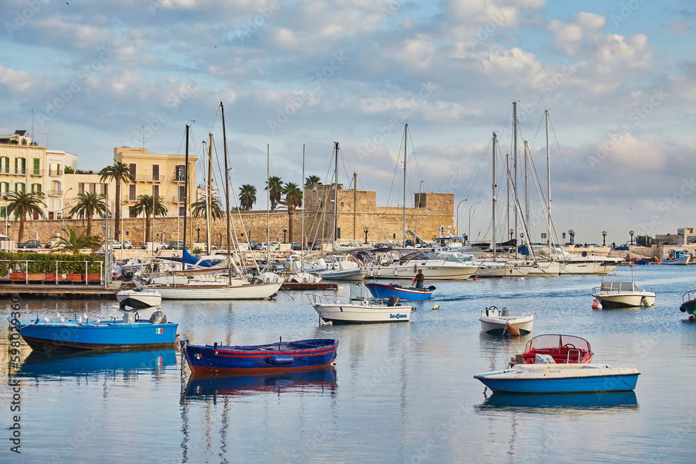Bari town skyline and fishing boats - harbor in Apulia region.