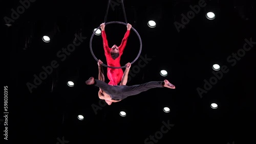 Aerial hoop duo on black background doing performance. Concept of romantic relationship in couple  Generative AI