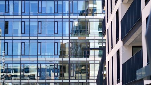 Abstract fragment of contemporary architecture, walls made of glass and concrete. Abstract closeup of the glass-clad facade of a modern building covered in reflective plate glass.