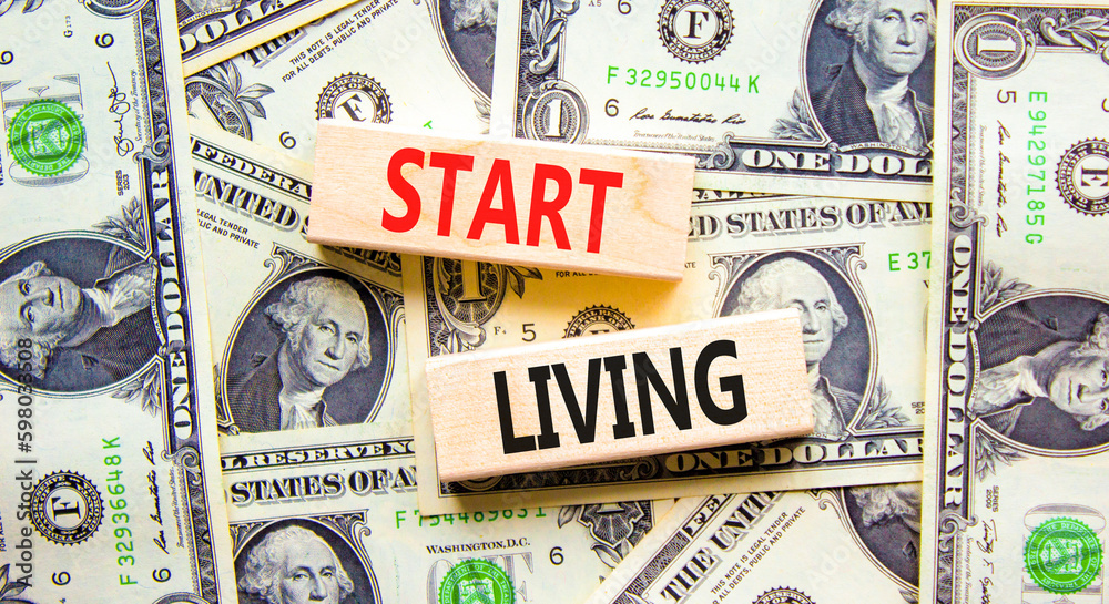 Start living symbol. Concept words Start living on beautiful wooden block. Beautiful background from dollar bills. Business and Start living concept. Copy space.