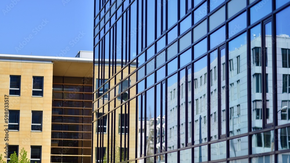 Abstract fragment of contemporary architecture, walls made of glass and concrete. Abstract closeup of the glass-clad facade of a modern building covered in reflective plate glass. Abstract fragment of contemporary architecture, walls made of glass and concrete. Abstract closeup of the glass-clad facade of a modern building covered in reflective plate glass.