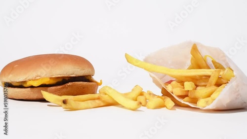 Mcdonalds food, still life of french fries and cheeseburger on white background. Fast food studio shoot video, happy meal 4k photo