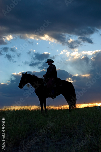 Cowboy on horseback at dawn
