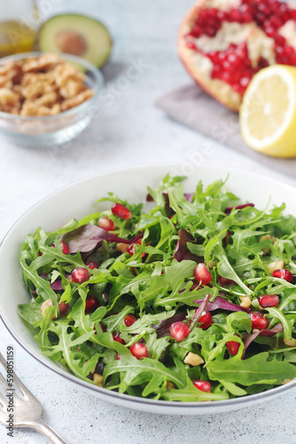 A plate with green rocket salad with pomegranate