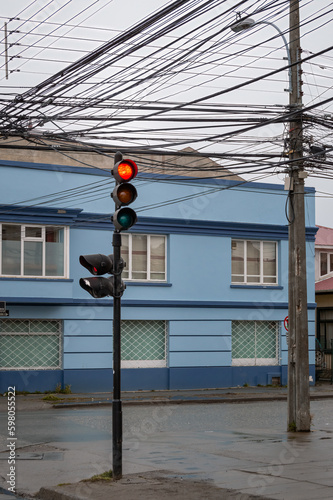 Red semaphore signal  below a chotic electric wiring at Punta Arenas photo