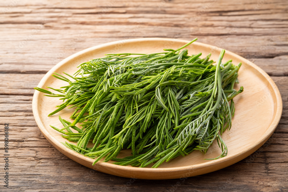 young leaves,Leucaena leucocepphala,Thai local vegetables,food High in phosphorus on wooden plate. young leaves,Leucaena leucocepphala,Thai local vegetables,food High in phosphorus on wooden plate.